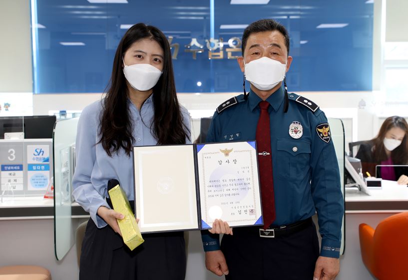 ▲임다연 Sh수협은행원이 보이스피싱 피해를 막아서울 금천경찰서로부터 감사장을 받고 기념 촬영을 하고 있다.  (사진제공=Sh수협은행)