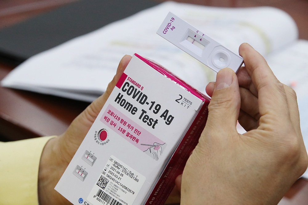 ▲30일 정부서울청사에서 홍남기 국무총리 직무대행 주재로 열린 코로나19 대응 중앙재난안전대책본부(중대본) 회의에서 참석자가 '자가 진단키트'를 보고 있다. (연합뉴스)