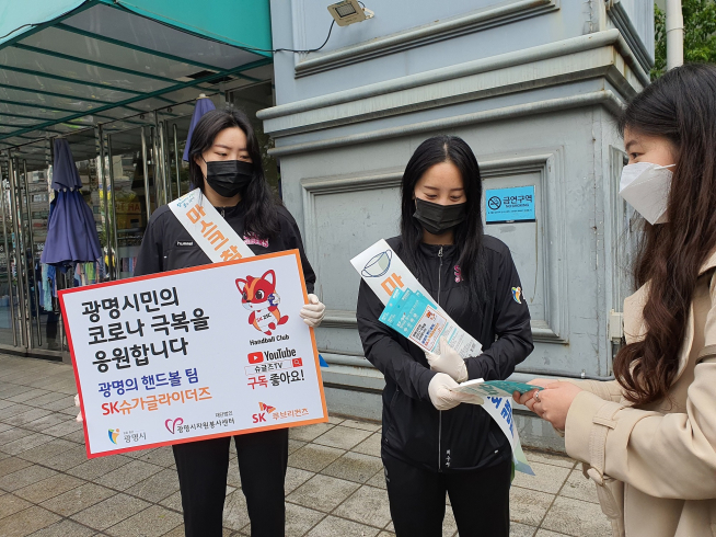 ▲SK슈가글라이더즈 이한솔(왼쪽), 최수지 선수가 광명시민에게 마스크를 나눠주고 있다. (사진제공=SK루브리컨츠)
