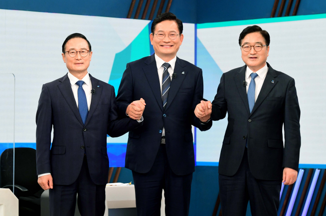 ▲더불어민주당 당대표 경선에 출마한 홍영표(왼쪽부터), 송영길, 우원식 후보가 27일 서울 여의도 KBS에서 열린 더불어민주당 당 대표 후보자 토론회에서 함께 손을 잡고 기념촬영하고 있다.   (연합뉴스)