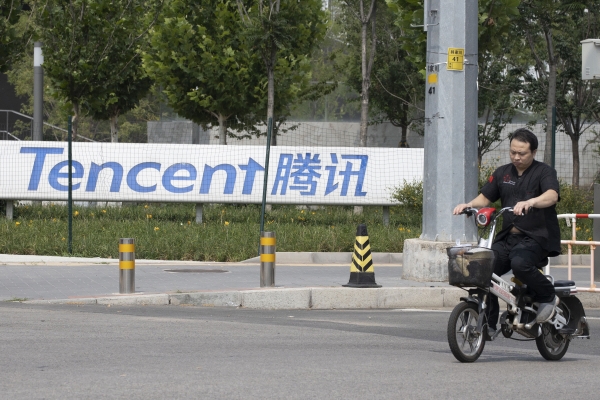 ▲지난해 8월 7일 오토바이를 탄 한 남성이 텐센트 베이징 본사 앞을 지나고 있다. 베이징/AP뉴시스
