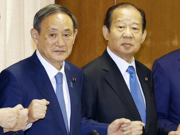 ▲스가 요시히데(왼쪽) 일본 총리와 자민당의 니카이 도시히로 간사장이 지난해 9월 도쿄 자민당 당사에서 취재진을 바라보고 있다. 도쿄/AP뉴시스