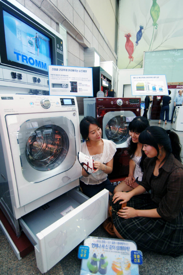 ▲2008년 출시한 드럼세탁기에 탑재된 서랍형 신발관리기를 고객들이 체험하는 모습 (사진제공=LG전자)
