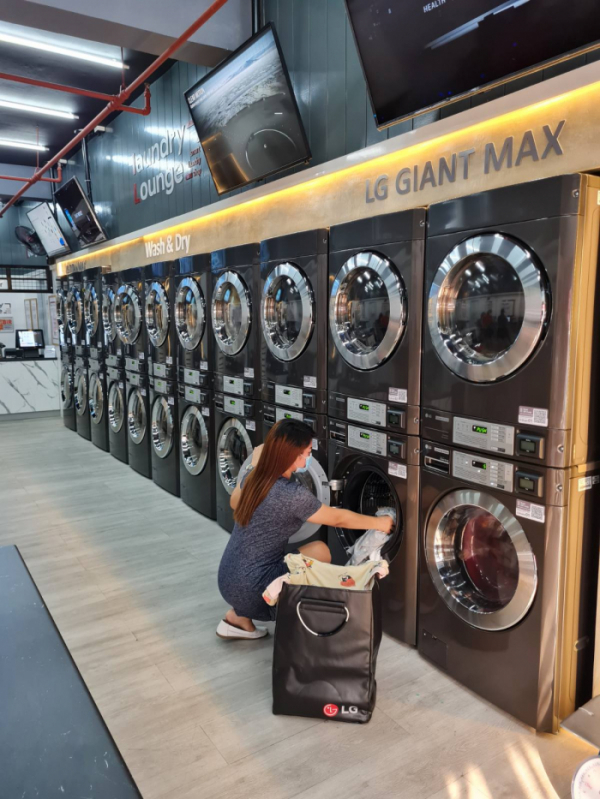 ▲LG전자가 최근 오픈한 필리핀 마닐라 소재 '스마트 론드리 라운지(Smart Laundry Lounge)'에 상업용 세탁기·건조기를 공급했다. 고객이 ‘스마트 론드리 라운지’에서 LG 상업용 세탁기를 사용하고 있다. (사진제공=LG전자)