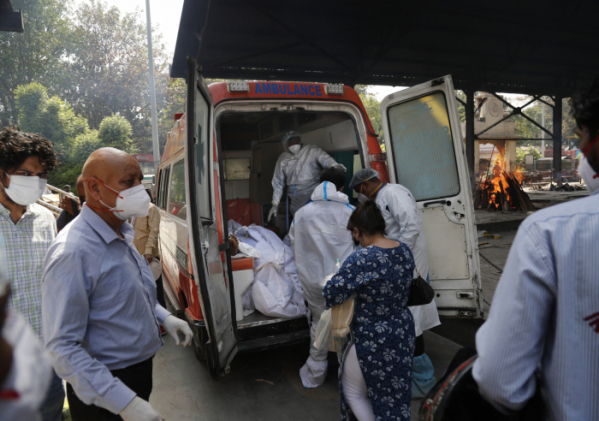 ▲인도 뉴델리에서 15일(현지시간) 보건당국 관계자들이 코로나19 사망자 시신을 앰뷸런스로 옮기고 있다. 뉴델리/AP뉴시스