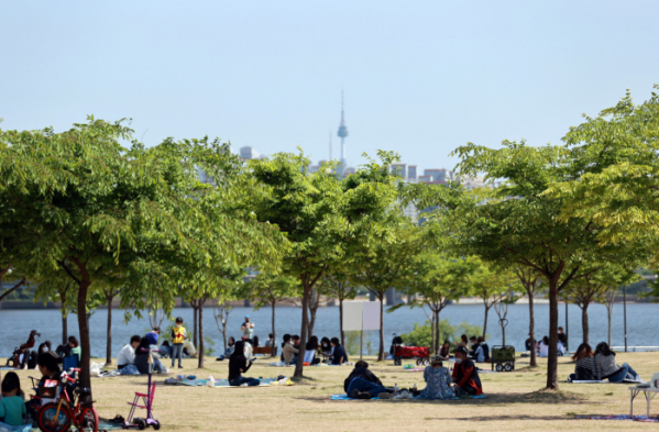 ▲25일 서울 영등포구 여의도 한강시민공원을 찾은 시민들이 나무 그늘 아래에서 휴식을 취하고 있다. (연합뉴스)