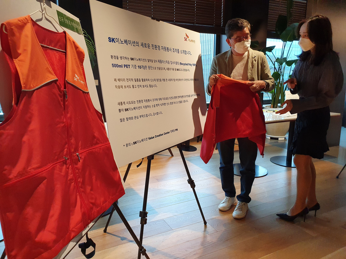 ▲SK종합화학 나경수(왼쪽) 사장이 지난 29일, 서울 종로구 SK서린사옥에서 폐플라스틱을 업사이클링해서 만든 자원봉사 조끼를 살펴보고 있다. (사진제공=SK이노베이션)