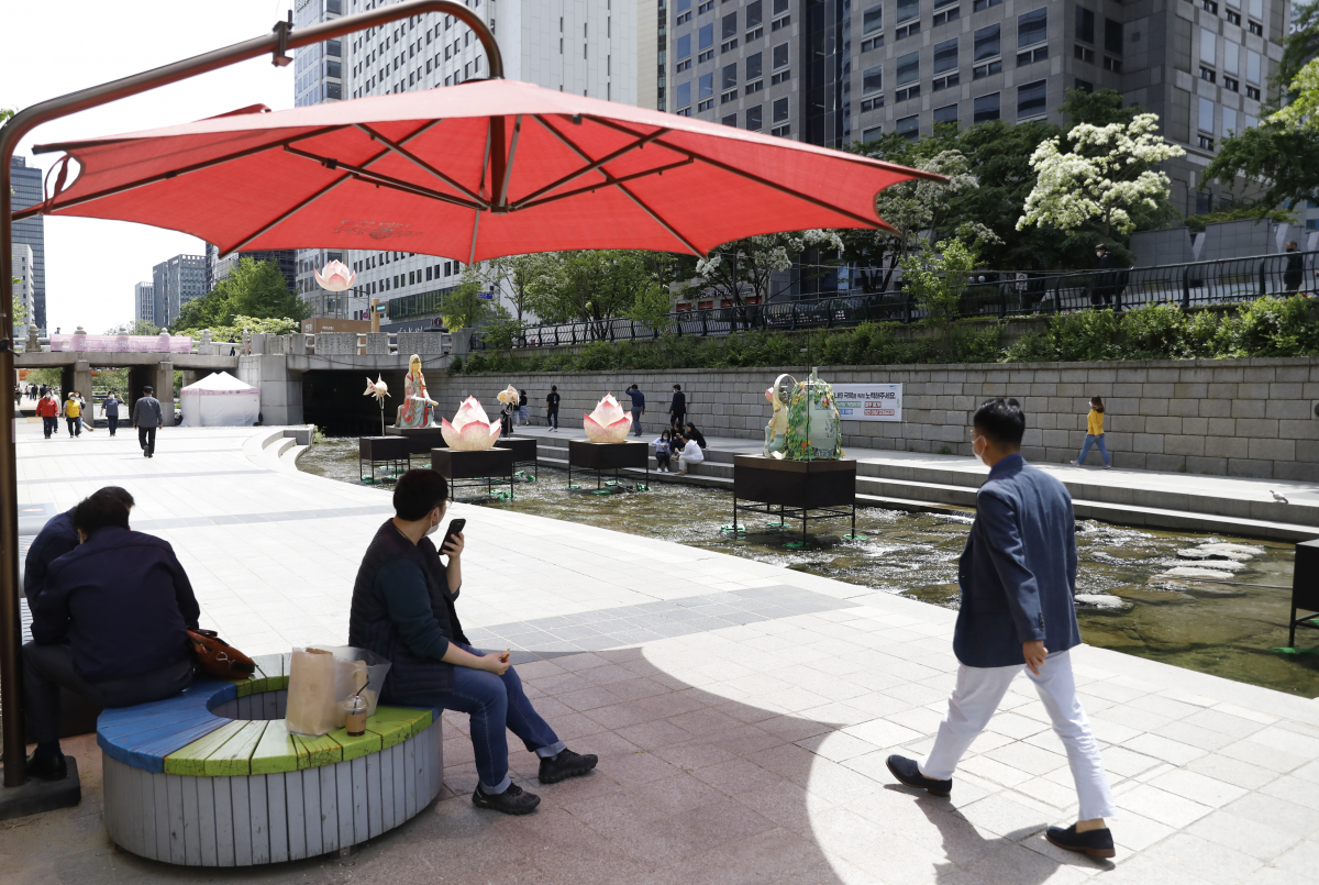 ▲수도권 한낮 기온이 26도까지 오르며 초여름 날씨를 보인 11일 서울 청계천에서 시민이 파라솔을 이용하고 있다. (뉴시스)