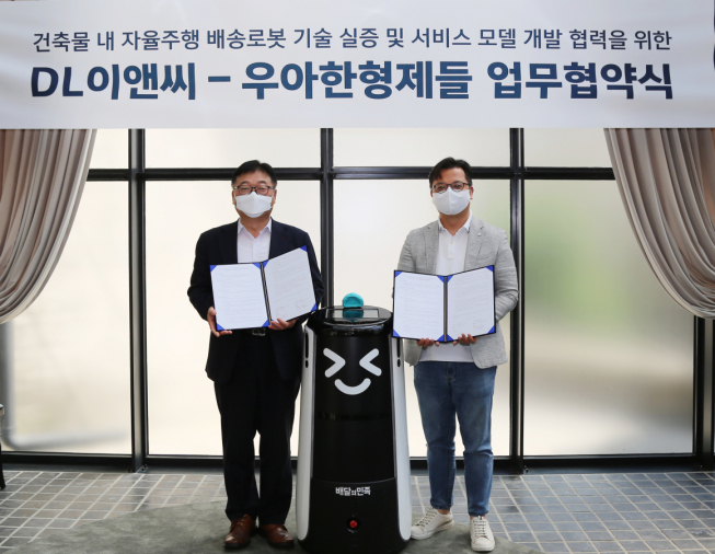 ▲DL이앤씨는 14일 배달앱 ‘배달의민족’ 운영사 우아한형제와 배송로봇 기술 개발을 위한 업무 협약을 체결했다고 밝혔다. 나재현(왼쪽) DL이앤씨 주택사업본부 엔지니어링실장과 김요섭 우아한형제들 로봇사업실장(우측)이 협약식 직후 기념촬영을 하고 있다.
(사진제공=DL이앤씨)