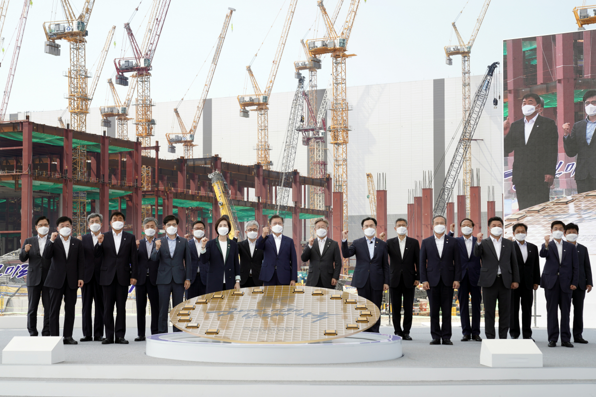 ▲문재인 대통령이 13일 오후 경기 평택시 삼성전자 평택단지 3라인 건설현장에 마련된 야외무대에서 열린 'K-반도체 전략 보고'에서 '반도체 생태계 강화 연대 협력 협약식'을 마친 후 참석자들과 기념촬영을 하고 있다. 연합뉴스