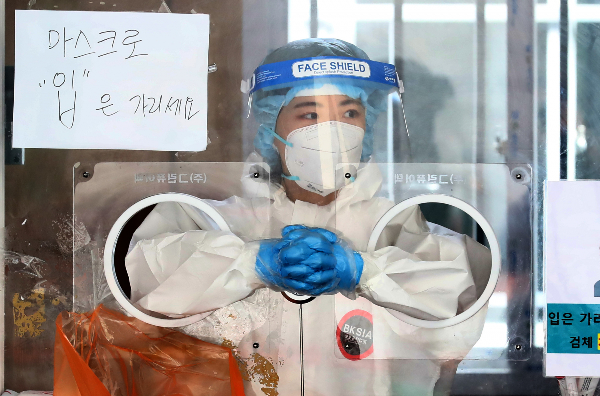 ▲18일 오전 서울 중구 서울역광장에 마련된 코로나19 임시선별검사소에서 한 의료진이 검체채취를 위해 대기하고 있다. (사진제공=뉴시스)