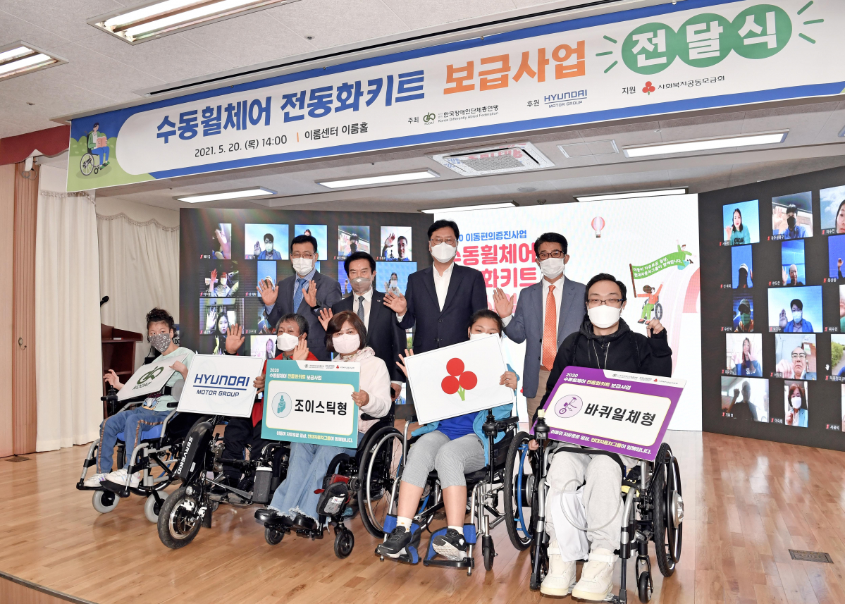 ▲현대차그룹이 장애인 이동편의를 위해 수동휠체어 전동화키트 보급/셰어링 사업을 3년째 이어간다. 현대차그룹은 20일 서울 여의도 이룸센터에서 이병훈 현대차그룹 상무, 최공열 한국장애인단체총연맹 상임대표 등 행사 관계자들이 참석한 가운데 ‘수동휠체어 전동화키트 보급사업 전달식’을 가졌다. 사진 왼쪽부터 김동범 한국장애인단체총연맹 사무총장, 최공열 한국장애인단체총연맹 상임대표, 이병훈 현대차그룹 상무, 변승일 한국장애인단체총연맹 공동대표가 전동화키트를 전달받은 장애인 다섯 명과 기념촬영을 하고 있다. (사진제공=현대차그룹)