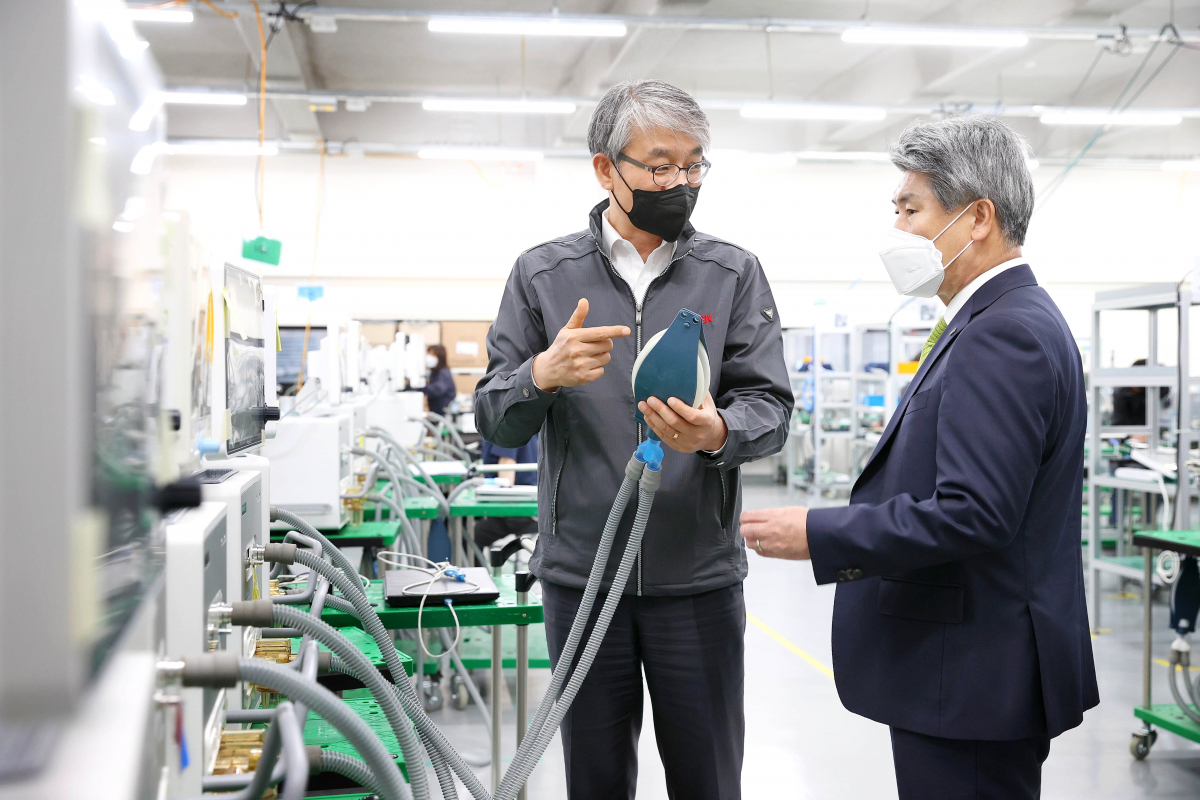 ▲21일 윤종원 기업은행장(오른족)이 경기도 파주에 위치한 인공호흡기 제조 기업 멕아이씨에스를 방문해 김종철 대표(왼쪽)로부터 생산공정에 대해 설명을 듣고 있는 모습