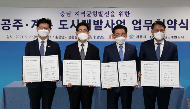 ▲(왼쪽부터 순서대로)김정섭 공주시장, 양승조 충남도지사, 최홍묵 계룡시장, 정석완 충남개발공사 사장이 27일 충남도청에서 '충남 지역 균형 발전을 위한 공주·계룡 도시개발사업 추진을 위한 업무협약' 체결 후 기념촬영을 하고 있다. (사진제공=충청남도)