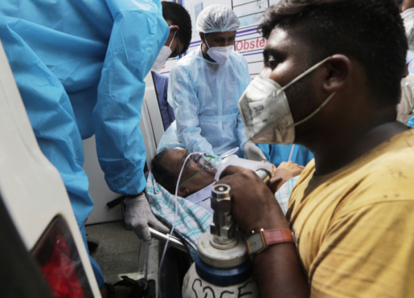 ▲지난달 23일(현지시간) 인도 뭄바이 인근 비라르의 비제이 발라브 병원에서 불이 나 보건 종사자들이 환자를 옮기고 있다. 현지 당국은 이 화재로 코로나19 환자 13명이 숨졌다고 밝혔다. (AP/뉴시스)