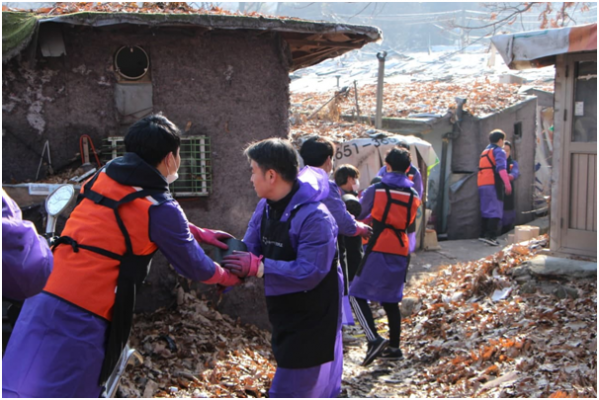 ▲빗썸 임직원들이 지난해 1월 서울 개포동 구룡마을에서 ‘사랑의 연탄나눔‘ 봉사활동을 하는 모습이다. (사진제공=빗썸코리아)