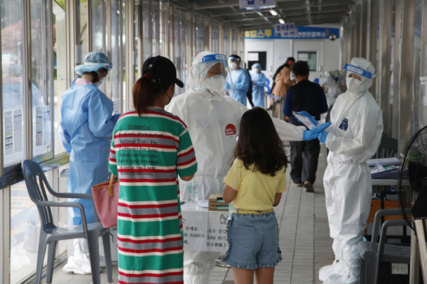 ▲12일 서울 시내 한 보건소 코로나19 선별진료소에서 검사를 받으려는 시민들이 의료진으로부터 안내를 받고 있다. (뉴시스)