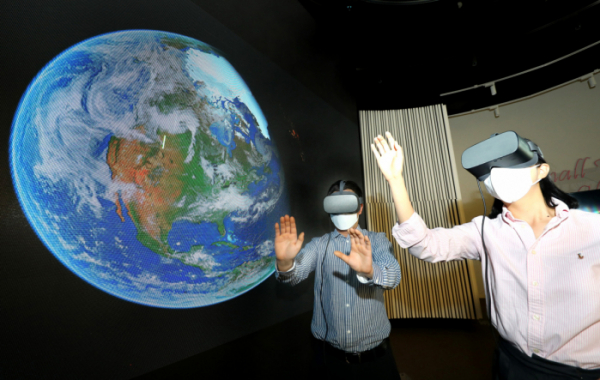 ▲LG유플러스 관계자들이 우주를 배경으로 한 스튜디오에서 U+VR의 신규 콘텐츠를 감상하고 있다. (사진제공=LG유플러스)