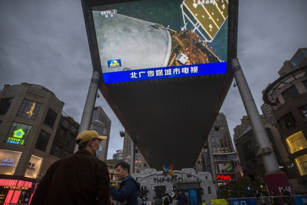 ▲중국 베이징의 한 쇼핑몰 앞 대형 스크린에 15일 무인 탐사선 톈원 1호의 화성 착륙 소식이 방송되고 있다. 베이징/AP연합뉴스 

