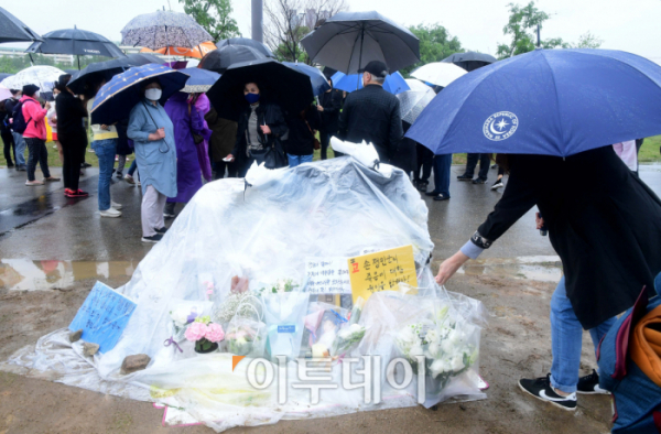 ▲16일 서울 반포한강공원 수상택시 승강장 인근에서 ‘고 손정민 군을 위한 평화집회’가 열린 가운데 한 시민이 손 군을 추모하며 헌화하고 있다. 신태현 기자 holjjak@