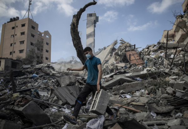 ▲가자지구의 한 시민이 18일(현지시간) 오전 이스라엘 공습으로 무너진 6층짜리 건물 잔해에 서 있다. AP뉴시스 