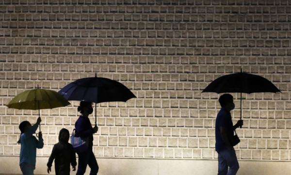 ▲절기상 소만을 하루 앞둔 20일 오후 서울 종로구 경복궁에서 시민들이 우산을 쓴 채 발걸음을 재촉하고 있다 (뉴시스)