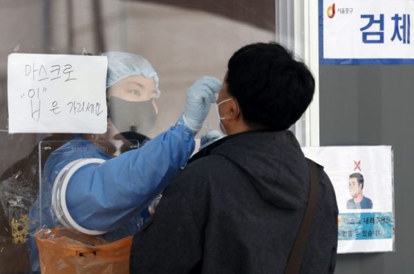 ▲20일 서울역 광장에 마련된 중구 임시 선별검사소에서 의료진이 한 시민의 검체를 채취하고 있다.  (뉴시스)
