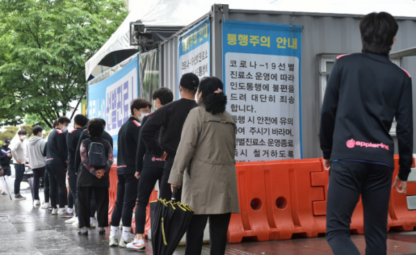 ▲지난 17일 대구 동구 보건소 선별진료소에서 시민들이 검사를 받기 위해 줄 서 기다리고 있다. (뉴시스)