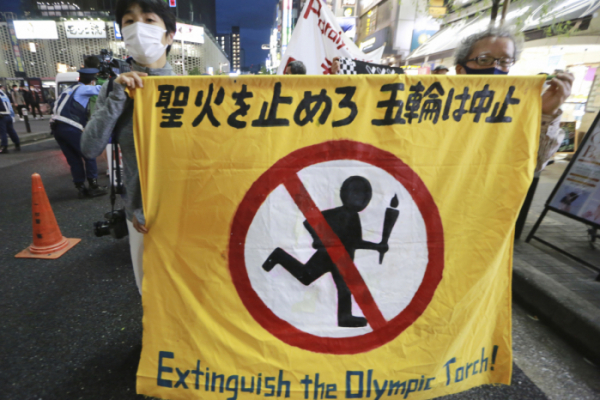 ▲한 일본 도쿄 시민이 17일(현지시간) "올림픽 성화를 꺼라"라는 배너를 들고 도쿄올림픽 개최를 반대하고 있다. AP뉴시스 