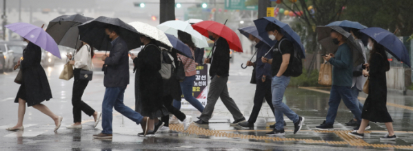 ▲25일 오전 서울 종로구 광화문광장에서 우산을 쓴 시민들이 출근하고 있다. (뉴시스)