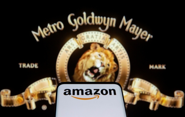 ▲26일(현지시간) MGM 로고 앞에 아마존 로고가 뜬 스마트폰 화면이 보인다. 로이터연합뉴스

