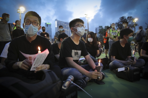 ▲홍콩 민주 운동가 조슈아 웡(오른쪽)과 네이선 로가 지난해 6월 4일 홍콩 빅토리아파크에서 톈안먼 민주화 시위 추모를 하고 있다. 홍콩/AP연합뉴스
