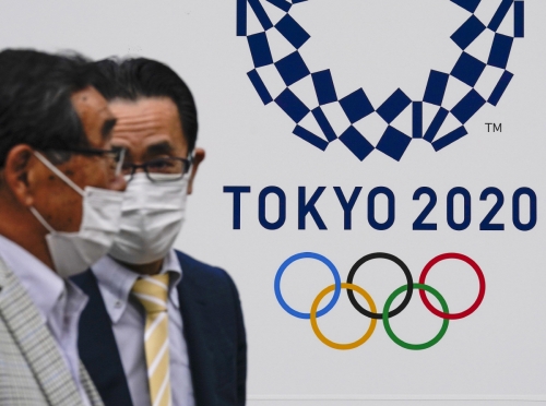 ▲도쿄올림픽 문구 앞을 지난달 28일(현지시간) 일본 남성 두 명이 지나가고 있다. 도쿄/EPA연합뉴스
