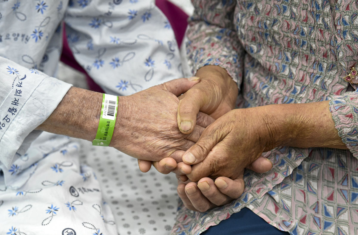 ▲요양병원·시설 입소자나 면회객 중 어느 한쪽이라도 코로나19 예방접종 완료자(2차 접종 후 2주 경과)인 경우 대면 면회가 가능해진 1일 오전 경기도 안산시 단원구 경희재활요양병원에서 아내 이 모씨와 입소자인 남편 김 모씨가 대면 면회에서 두 손을 맞잡고 있다. (뉴시스)