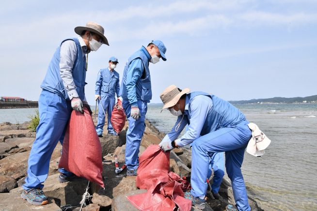 ▲민경준 포스코케미칼 사장(가운데)과 임직원들이 포항 청림동 해변에서 폐기물 수거 봉사활동을 하고 있다. (사진제공=포스코케미칼)