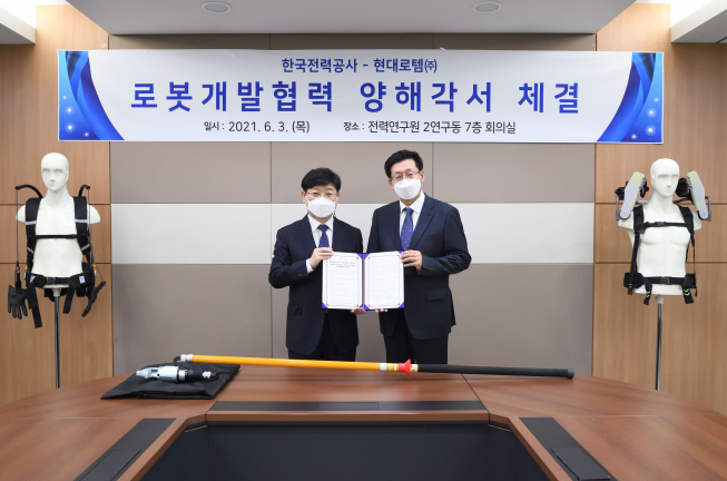 ▲3일 대전에 위치한 한전 전력연구원에서 송기욱 한전 전력연구원 융복합프로젝트연구소장(왼쪽)과 안경수 현대로템 디펜스솔루션사업본부장(오른쪽)이 기념촬영을 하고 있다. (사진제공=현대로템)