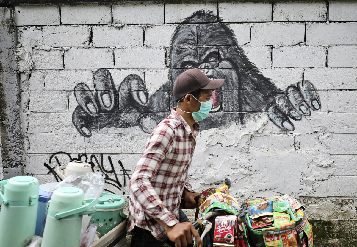 ▲인도네시아 자카르타에서 2월 10일(현지시간) 음료 판매상이 자전거를 타고 지나가고 있다. 자카르타/AP뉴시스