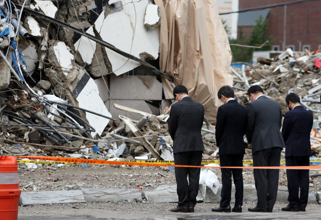 ▲ 정몽규(왼쪽 두 번째) HDC그룹 회장이 11일 오전 광주 학동 철거건물 붕괴 사고 현장을 찾아 헌화한 뒤 묵념을 하고 있다. (연합뉴스)