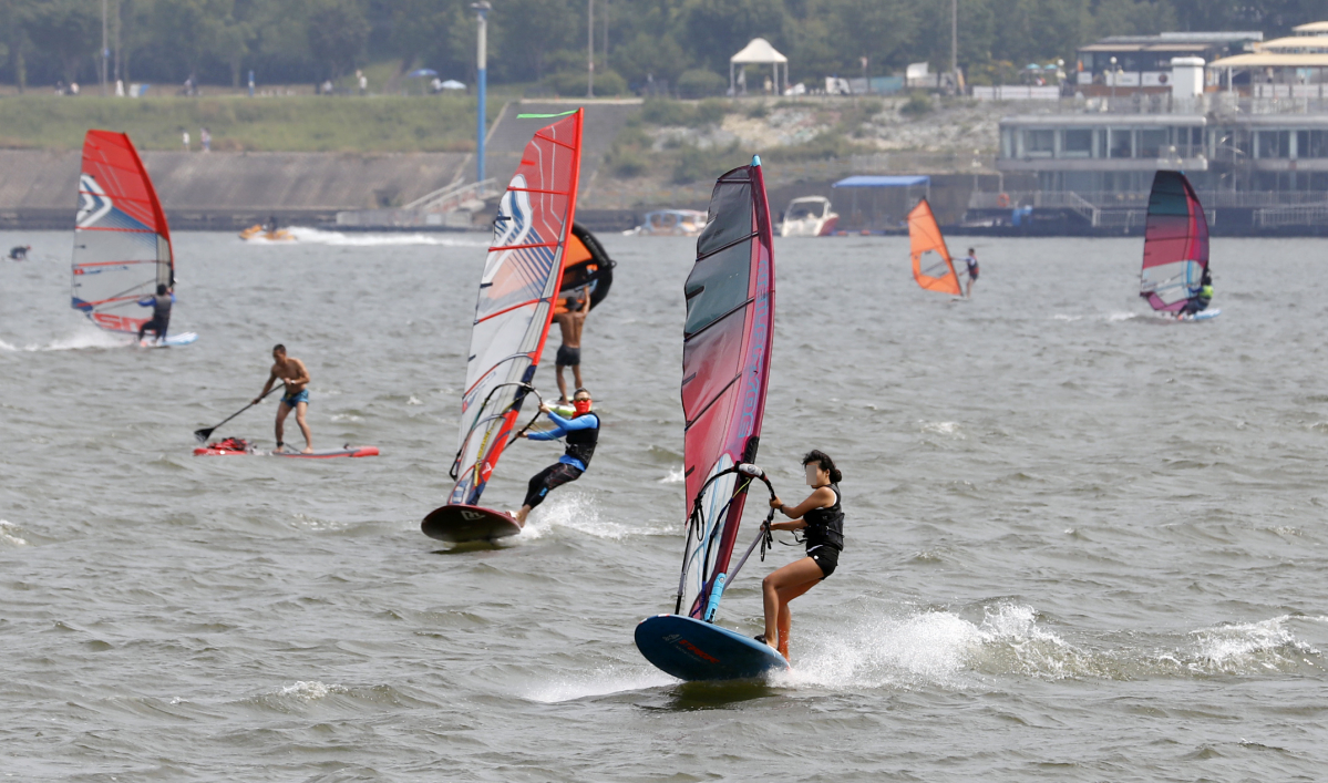 ▲서울 뚝섬한강공원 인근 한강에서 시민들이 윈드서핑을 즐기며 더위를 잊고 있다.  (뉴시스)