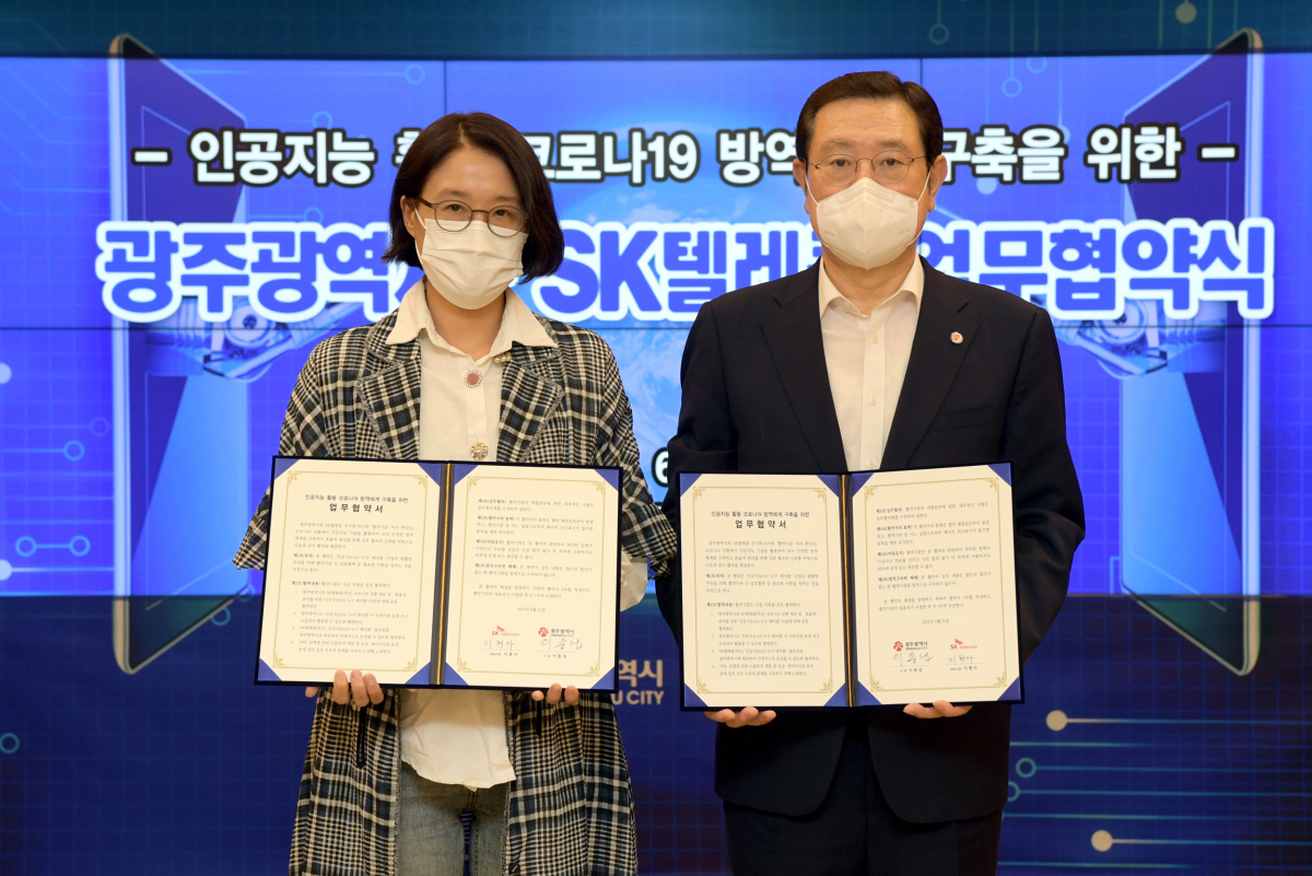 ▲이용섭(오른쪽) 광주광역시장이 21일 오후 시청 비느니스룸에서 SKT 이현아 AI&CO장과 인공지능 활용 코로나19 방역체계 구축을 위한 업무협약을 체결한 후 기념촬영을 하고 있다. (사진제공=SKT)