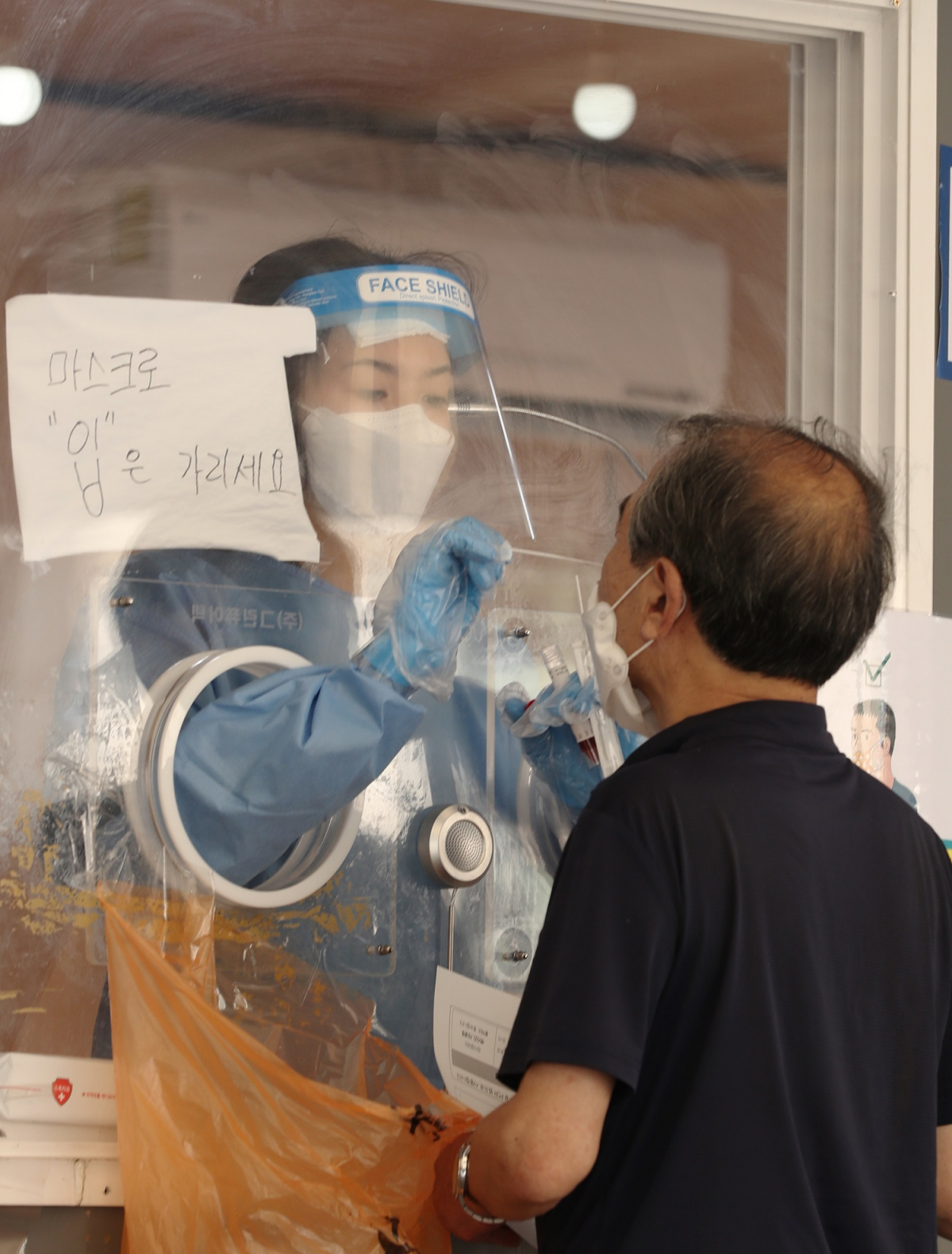 ▲25일 오전 서울 중구 서울역광장에 마련된 임시선별검사소에서 시민이 검사를 받고 있다.  (뉴시스)