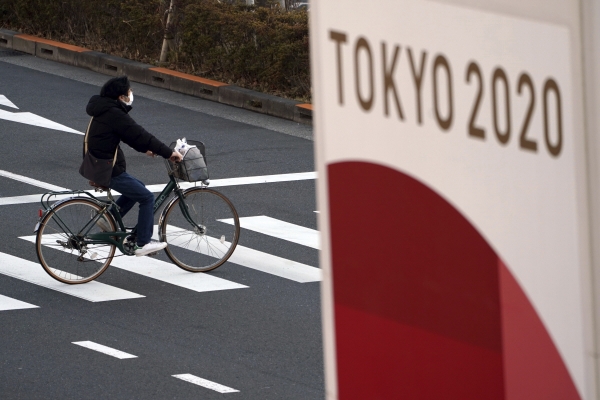 ▲일본 도쿄에서 한 남성이 1월 21일 자전거를 타고 올림픽 배너 옆을 지나고 있다. 도쿄/AP연합뉴스
