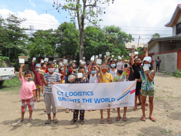 ▲필리핀 세부 지역의 전기 없는 가정 아동들이 CJ대한통운으로부터 받은 태양광 랜턴을 들고 있다. (사진제공=CJ대한통운)