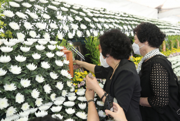 ▲11일 오전 광주 동구청 주차장에 마련된 학동4구역 재개발 붕괴사고 피해자 합동분향소에서 한 사망자의 오랜 친구들이 찾아와 영정사진을 어루만지고 있다. (연합뉴스)