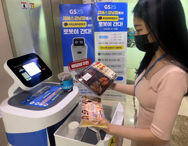 ▲고객이 GS25 로봇 배달 서비스로 주문한 상품을 수령하고 있다.  (사진제공=GS리테일)