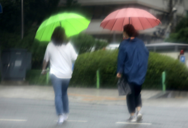 ▲벼락과 함께 갑작스럽게 쏟아진 소나기를 피해 시민이 서울 중구 남대문 인근 도로를 걸어가고 있다. (뉴시스)