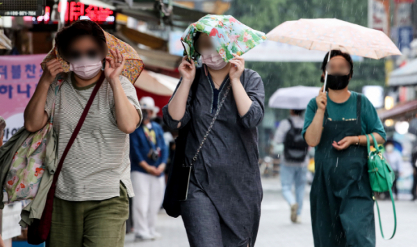 ▲소나기가 내린 23일 오후 서울 중구 남대문시장에서 시민들이 손수건을 이용해 비를 피하고 있다. (뉴시스)