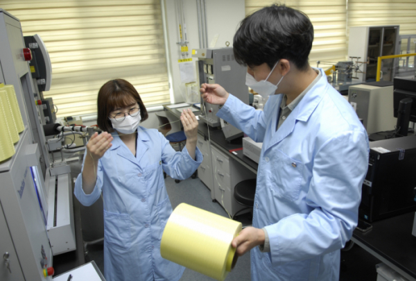 ▲코오롱인더스트리의 연구원들이 아라미드 섬유인 헤라크론 제품을 살피고 있다. (사진제공=코오롱인더스트리)