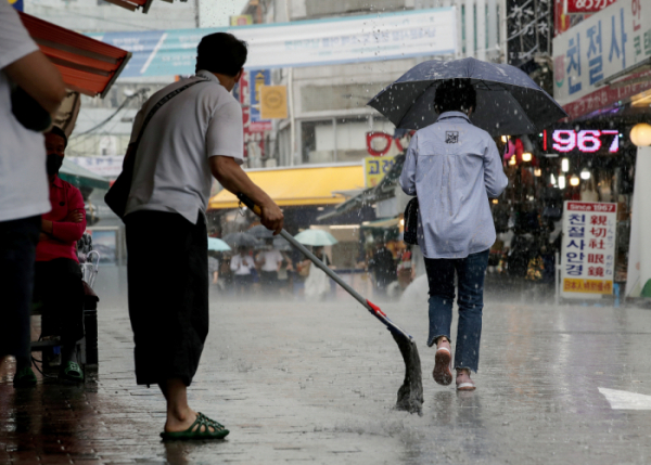 ▲소나기가 내리는 23일 오후 서울 중구 남대문시장에서 시민이 우산을 쓰고 있다.  (뉴시스)