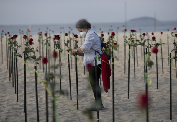 ▲팬데믹으로 50만명 이상이 사망한 브라질에서는 가뭄이 또 다른 위협이 되고 있다. 사진은 20일 한 여성이 리우데자네이루 코파카바나 해변에서 코로나19 사망자를 추모하기 위한 장미를 두는 모습이다. (AP/뉴시스)